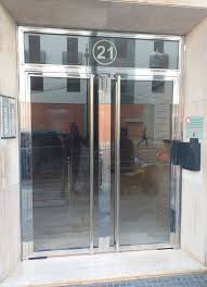 Portal acristalado de comunidad con marco inoxidable